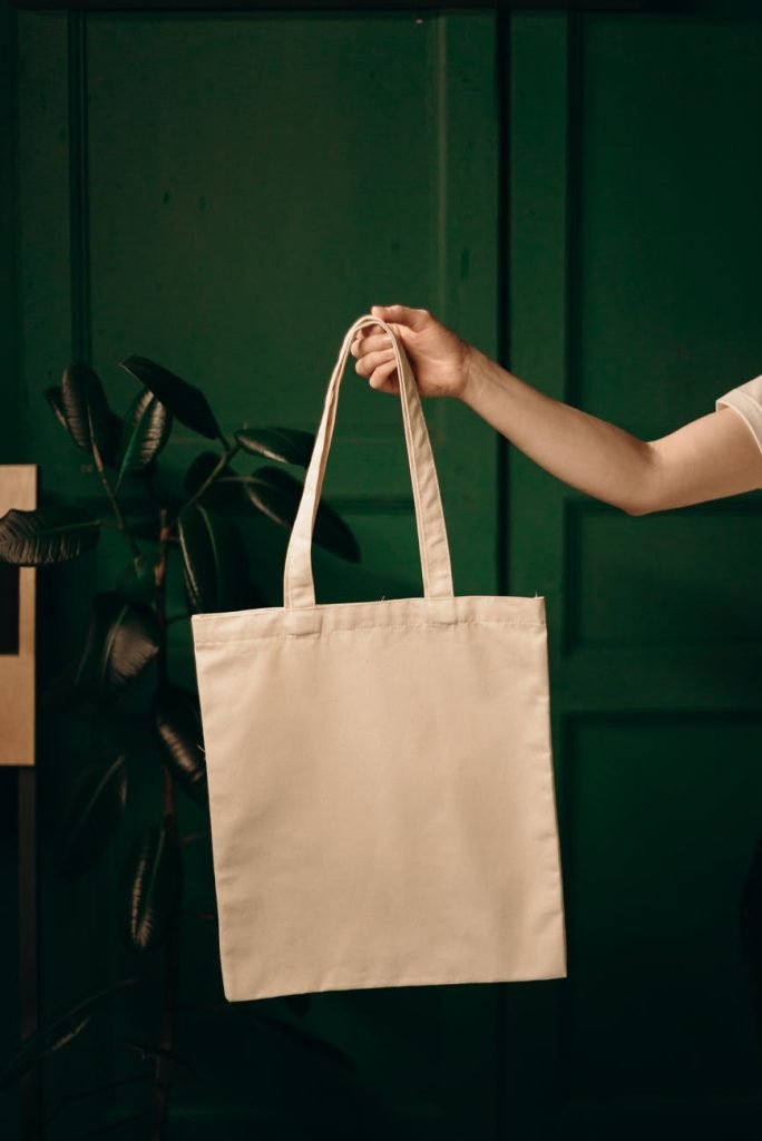 person holding white tote bag